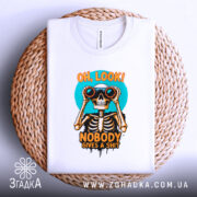 Футболка скелет з написом, біла, зображена на плоскій поверхні, фон світло-сірий, принт з черепом, що тримає бінокль, кольори принта яскраві: оранжевий, чорний, блакитний, на плетеній основі.