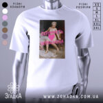 Футболка скромність переоцінена, біла, зображена на манекені, фон нейтральний, принт з класичним живописом та текстом рожевого кольору.