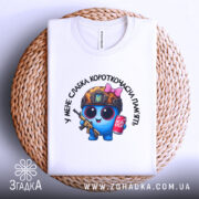 Футболка слабка пам`ять, біла, складена на плетеній основі, фон нейтральний, принт з персонажем у військовій касці, з автоматом та банкою напою, видно деталі принта.