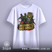 Футболка сміливість наш фронт, біла, підвішена на вішалці, фон світло-сірий, принт з трьома солдатами та гербом України, кольори принта чорний, жовтий, червоний.