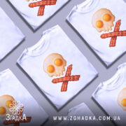 Футболка сніданок стиль, біла футболка на манекені, з принтом у вигляді черепа з яєчнею та хрестом з бекону, фон світло-сірий, деталі принта яскраві та чіткі.
