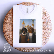 Футболка собаки мистецтво Києва, біла, зображена на плетеній основі, фон світлий, принт з двома собаками в одязі на фоні архітектури з золотими куполами.