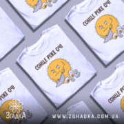 Футболка сонце ріже очі. Біла футболка з принтом жовтого сонця, яке тримає ніж. Принт розташований на грудях, фон світло-сірий, футболка на манекені.