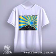 Футболка сонце в Україні, біла, підвішена на вішалці, фон світло-сірий, принт з жовтими та блакитними променями, чорні гори та синє сонце.