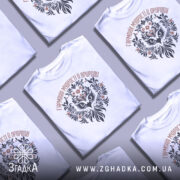 Футболка сова гармонія, біла, зображена на манекені, фон світло-сірий, принт з совою та рослинними елементами в чорному і коричневому кольорах.