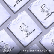 Футболка спочатку кавуся. Біла футболка на манекені, з принтом кота, що тримає чашку кави. Принт чорного кольору, зображує кота в шортах, на фоні світло-сірого кольору. Текст під принтом: 'ТССС.... СПОЧАТКУ КАВУСЯ'.