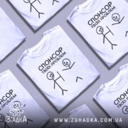 Футболка спонсор проблем — кілька складених футболок, композиція на столі.