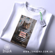 Футболка срав в тапок, біла, зображення кота в смугастій формі, вид зверху, принт з написом 'SRAV v TAPOK', на етикетці зелена стрічка.