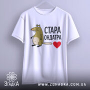 Футболка стара ондатра, білого кольору, зображена на вішалці, фон світло-сірий, принт з мультяшною ондатрою та написом 'СТАРА ОНДАТРА' чорного кольору з червоним сердечком.