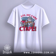 Футболка старе скелет, біла, підвішена на вішалці, фон світло-сірий, принт з черепом за кермом автомобіля, текст червоним кольором 'Бля, яке я вже СТАРЕ!'.