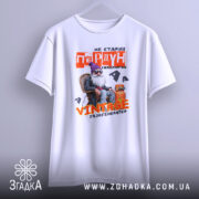 Футболка старий пердун. Біла футболка з коротким рукавом, зображена з легким нахилом. Фон світло-сірий. Принт з дідусем у фіолетовій шапці, текст червоний і жовтий, виглядає яскраво і привертає увагу.