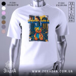 Футболка стоп війна, біла, зображена на манекені, фон нейтральний, принт з ведмедиком у кольоровій палітрі на фоні зруйнованого міста.