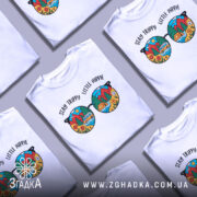 Футболка стиль хіпі, біла, зображена на манекені, фон світло-сірий, принт у вигляді кольорових окулярів з пейзажем, текст 'STAY TRIPPY LITTLE HIPPIE' над окулярами.