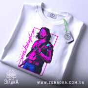 Футболка стиль кіберпанк, біла, зображена в горизонтальному положенні, фон світло-сірий, принт зображує персонажа з коротким волоссям у темних окулярах, одягненого в чорний жилет, кольори принта - фіолетовий і зелений, на футболці є етикетка з зеленим шнурком.