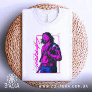 Футболка стиль кіберпанк, біла, зображена в горизонтальному положенні на плетеній основі, фон світло-сірий, принт зображує персонажа з коротким волоссям у темних окулярах, одягненого в чорний жилет, кольори принта - фіолетовий і зелений, текст на принті - 'Cyberpunk 2077'.