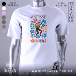 Футболка стиль Матісса, біла, зображена на манекені, фон світло-сірий, принт з кольоровими квітами та фігурою людини в чорному.