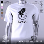 Футболка стиль NASA, біла, зображена на манекені, фон світло-сірий, принт з ракетою та Землею в чорному кольорі, текст 'NASA' під принтом.