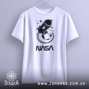 Футболка стиль NASA, біла, підвішена на вішалці, фон світло-сірий, принт з ракетою та Землею в чорному кольорі, текст 'NASA' під принтом.