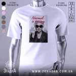 Футболка стильна бабуся, біла, з прямим ракурсом, на фоні світло-сірого кольору, принт з зображенням бабусі в чорних окулярах, з червоними губами, в шкірянці, з написом 'Normal is boring' червоним шрифтом.