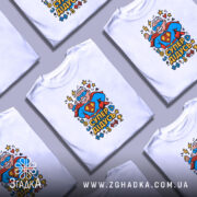 Футболка супер дідусь — кілька складених футболок, композиція на столі.