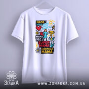 Футболка супер мама, біла, підвішена на вішалці, фон світло-сірий, принт кольоровий з текстом та малюнками, включаючи фігурку жінки в капелюсі.