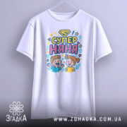 Футболка супер няня, білого кольору, підвішена на вішалці, фон світло-сірий, принт з дітьми та написом 'СУПЕР НЯНЯ' у яскравих кольорах.