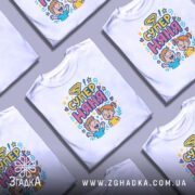 Футболка супер няня, білого кольору, зображена на манекені, фон світло-сірий, принт з веселими дітьми та написом 'СУПЕР НЯНЯ' у яскравих кольорах.