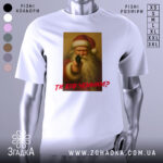 Футболка суворий Санта, біла, зображена з фронтального ракурсу, фон нейтральний, принт з зображенням Санти з пістолетом, текст червоним шрифтом "ТИ БУВ ЧЕМИМ?".