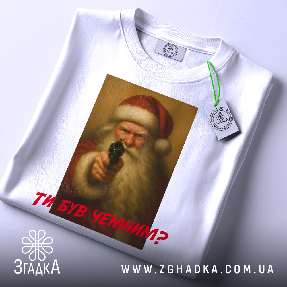 Футболка суворий Санта, біла, зображена зверху, фон світлий, принт з зображенням Санти з пістолетом, текст червоним шрифтом "ТИ БУВ ЧЕМИМ?", на футболці є етикетка.