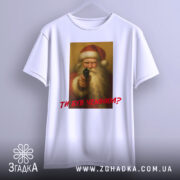 Футболка суворий Санта, біла, підвішена на вішалці, фон нейтральний, принт з зображенням Санти з пістолетом, текст червоним шрифтом "ТИ БУВ ЧЕМИМ?".