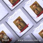 Футболка суворий Санта, біла, зображена з фронтального ракурсу, фон нейтральний, принт з зображенням Санти з пістолетом, текст червоним шрифтом "ТИ БУВ ЧЕМИМ?".