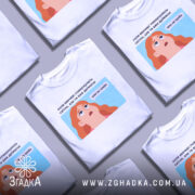 Футболка світла вже не треба. Біла футболка з коротким рукавом, зображена на манекені з ближнього ракурсу. На фоні світло-сірий градієнт. Принт з ілюстрацією дівчини з рудим волоссям, яка дивиться вгору, з текстом на українській мові.