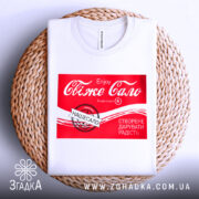 Футболка свіже сало білого кольору, складена на плетеній основі, з принтом червоного кольору, на якому написано "Свіже сало" та інші деталі, фон світлий.