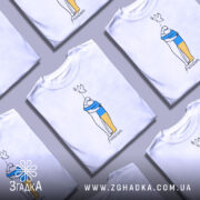 Футболка свобода Україна, біла, зображена на манекені з ближнього ракурсу, фон нейтральний, принт з двома фігурами, одна з яких тримає жовту і синю смугу, напис 'freedom' під малюнком.