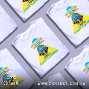 Футболка свого не цурайтесь, біла футболка з коротким рукавом, зображення прибульця в синьому капелюсі з квітами, жовтий трикутник з написом червоним кольором, фон світло-сірий.