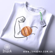 Футболка сила хліба, складена біла футболка з принтом на поверхні, зображення руки з м'ячем хліба, фон світло-сірий, на футболці є етикетка з зеленим шнурком.