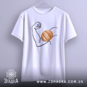 Футболка сила хліба, біла футболка підвішена на вішалці, зображення руки з м'ячем хліба на передній частині, фон світло-сірий, принт виконаний у чорному кольорі.