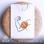 Футболка сила хліба, складена біла футболка на плетеній кошику, зображення руки з м'ячем хліба, фон світло-сірий, принт виконаний у чорному кольорі.