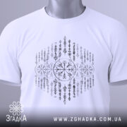 Футболка сила предків. Біла футболка, складена на поверхні, з видимим принтом у чорному кольорі. На футболці видно етикетку з зеленим шнурком, що додає акценту. Фон світло-сірий, що створює контраст з футболкою.