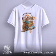 Футболка сила в голові, біла, зображена з фронтального ракурсу, фон нейтральний, принт з совою з коричневим пір'ям та блакитними елементами, текст 'Сила в голові!!' над совою.