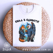 Футболка сила в єдності, біла, зображена зверху на плетеній основі, фон білий, принт з лисицею та орлом, які стискають руки, на лисиці броня, на орлі светр.