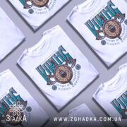 Футболка сила вікінга, біла, зображена на манекені, фон світло-сірий, принт з написом 'VIKING' у зелених та чорних кольорах, з зображенням щита та сокири.