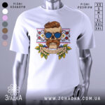 Футболка сила волі. Біла футболка з принтом, що зображає череп з вусами та сонцезахисними окулярами, на фоні вишиванки. Принт яскравий, з елементами зелені та написом 'GLORY TO UKRAINE'.