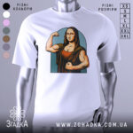 Футболка сильна моналіза, біла, зображена на манекені з правого боку, фон світло-сірий, принт зображає Моналізу з м'язами, що позує з кулаком, в кольорах коричневого та блакитного.