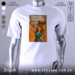 Футболка сильніша ніж думаю, біла, зображена на манекені, фон світло-сірий, принт з жінкою, яка тримає чоловіка на руці, з ножем в іншій руці, з написом 'СИЛЬНІША, НІЖ ДУМАЮ'.