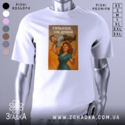 Футболка сильніша ніж думаю, біла, зображена на манекені, фон світло-сірий, принт з жінкою, яка тримає чоловіка на руці, з ножем в іншій руці, з написом 'СИЛЬНІША, НІЖ ДУМАЮ'.