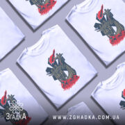 Футболка символ мужності. Білий колір, зображена на манекені з правого боку, фон світло-сірий, принт зображає фігуру жінки та чотирьох чоловіків на човні, оточених червоними хвилями.