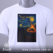 Футболка таке життя, біла, з верхнього ракурсу, на фоні світло-сірого кольору, складена, принт з зображенням кота на даху, текст 'ТАКЕ ЖИТТЯ' вгорі, з етикеткою на зеленому шнурку.