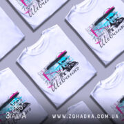 Футболка Тарас Григорович Шевченко, біла, зображена на манекені з блискучою поверхнею, фон світло-сірий, принт містить портрет Шевченка з кольоровими акцентами в блакитному та рожевому, текст на українській мові.