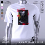 Футболка Тарас Шевченко подарунок, біла футболка з принтом, зображення Тараса Шевченка на чорному фоні, червоний текст з написом 'Зажурилась Україна – така її доля!', ракурс спереду, фон нейтральний.